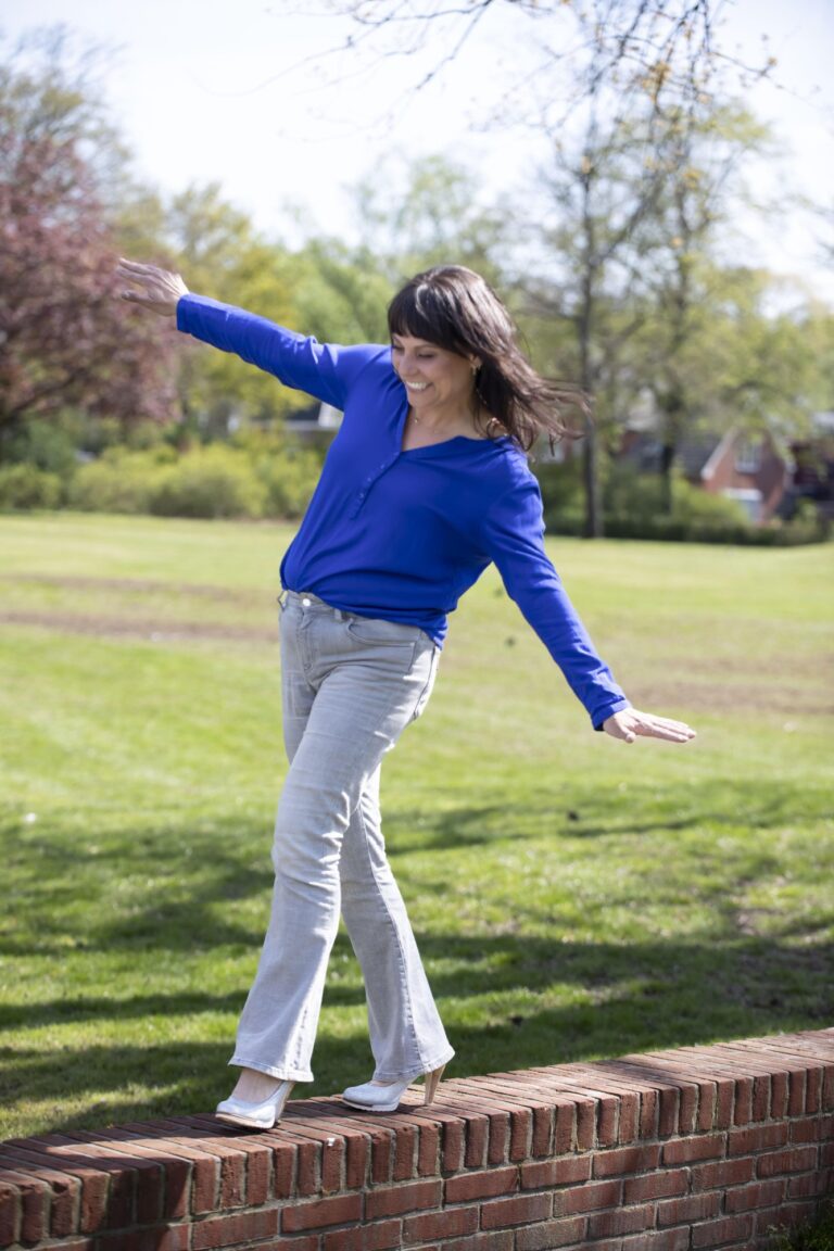 Angelique loopt met hakken over een muurtje
